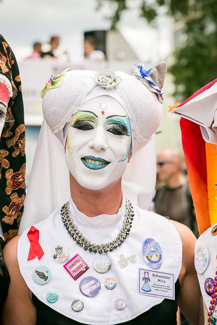 Drei Personen in phantasievollen Nonenkostümen und auffälligem Make-up posieren vor der Kamera. 