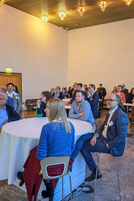 Ein Publikum hört bei einem Vortrag zu.