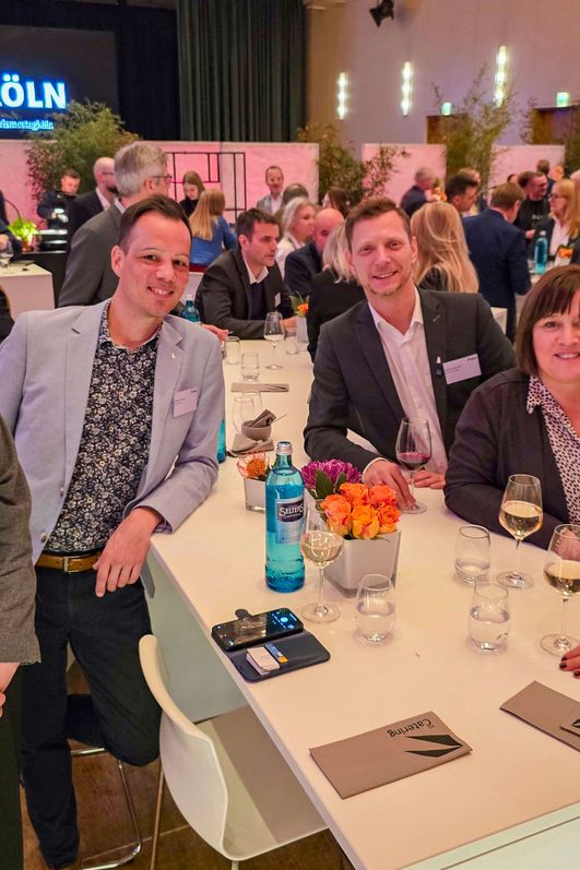 Eine Gruppe von fünf Personen lächelt in die Kamera.