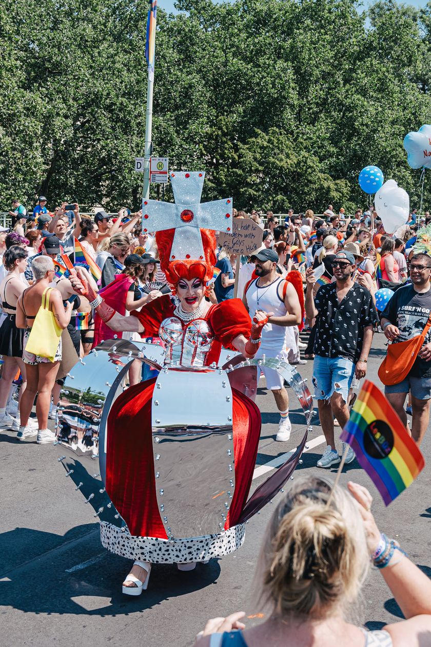 Die Pride Demonstration zieht friedlich durch die Straße mit Menschen in fantasievollen Kostümen.