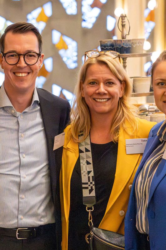 Vier Personen posieren lächelnd für die Kamera.