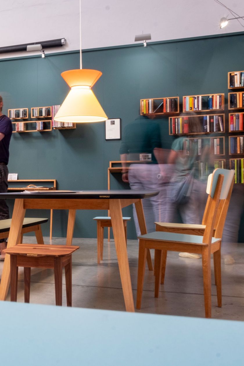 Ein heller Raum mit farblichen Akzenten an den Wänden. Minimalistische Designmöbel stehen im Raum. 