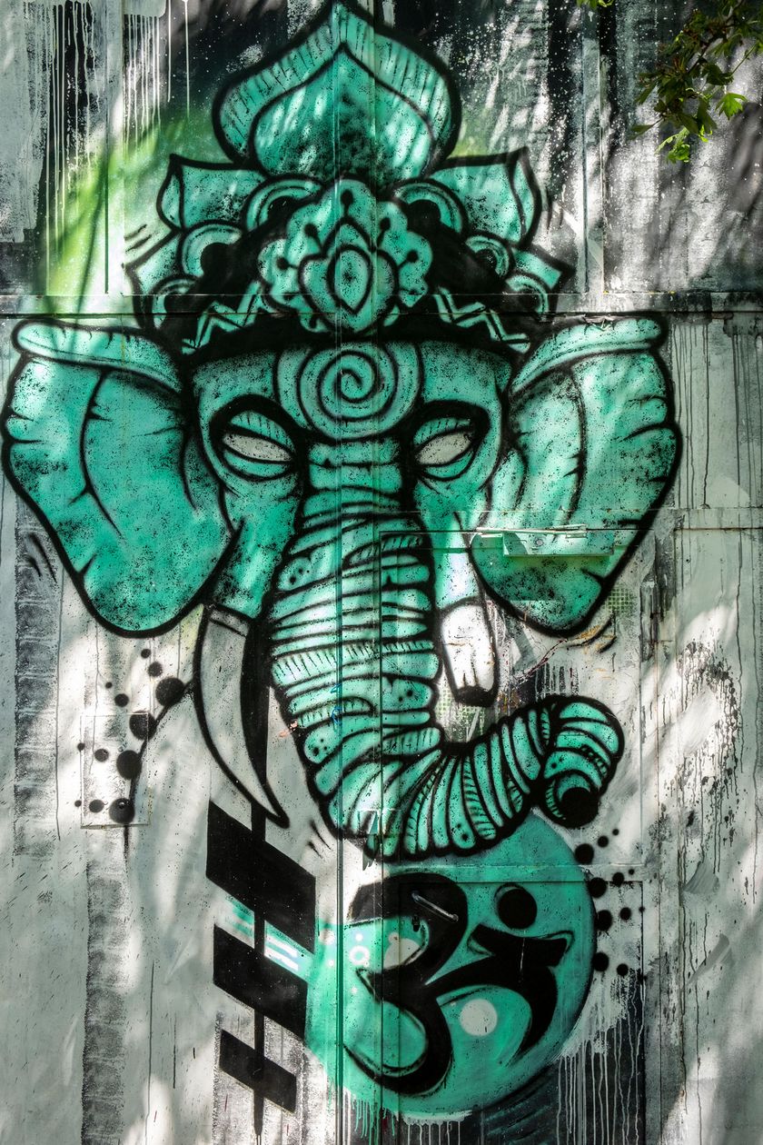 Ein Wandgemälde zeigt einen buddhistischen Elefanten Kopf in grüner Farbe.