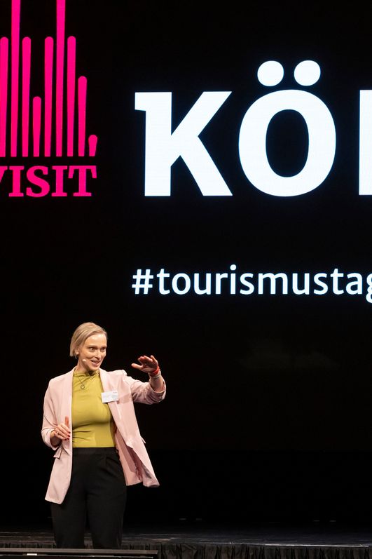 Eine Moderatorin spricht zu einem Publikum.