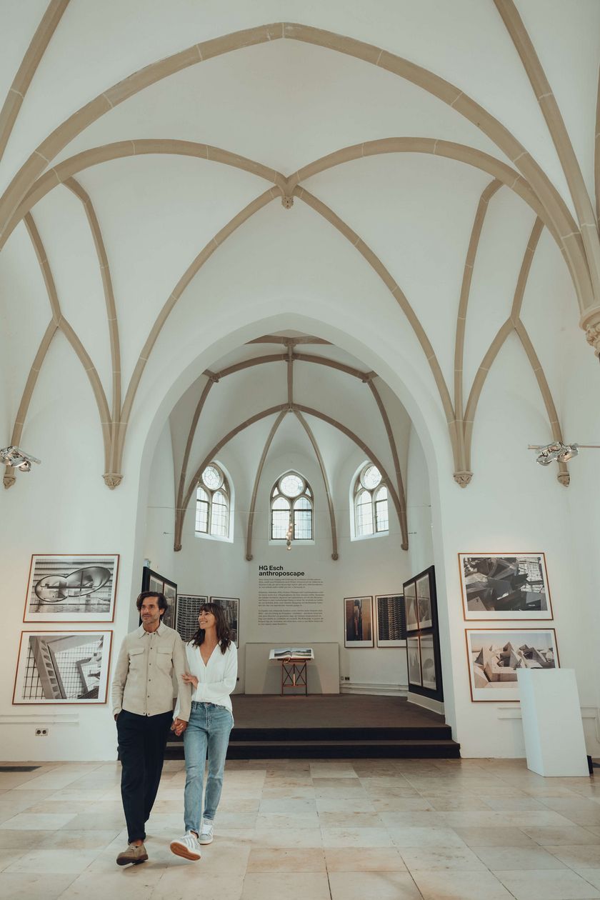 Zwei Personen laufen durch eine helle Kirche.
